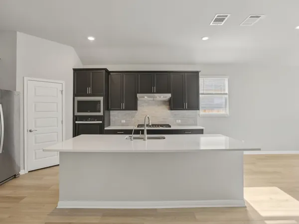 a view of a kitchen with center island and stainless steel appliances