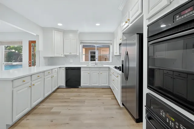 a large kitchen with a large window and stainless steel appliances
