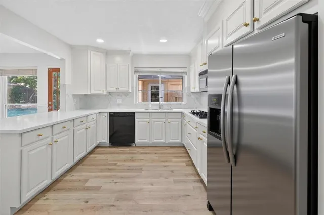 a kitchen with a refrigerator sink and cabinets