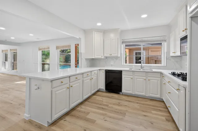 a kitchen with granite countertop white cabinets and white appliances