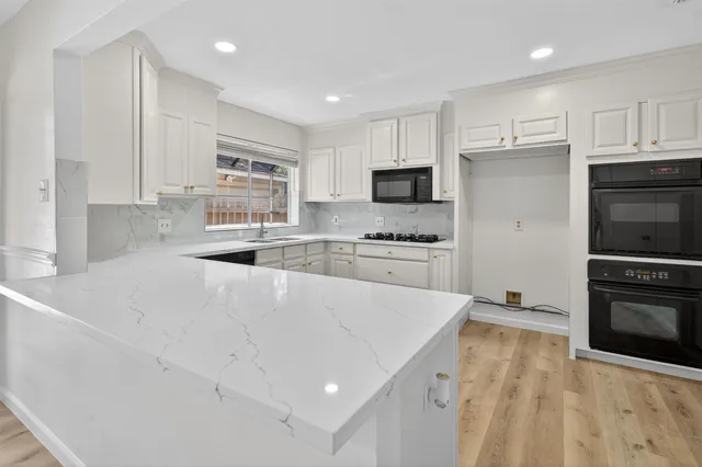 a kitchen with kitchen island a stove a sink and a refrigerator