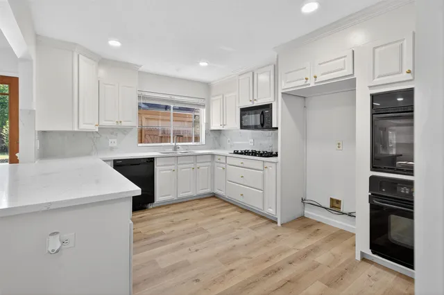 a kitchen with white cabinets and stainless steel appliances