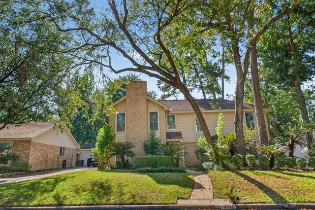 a front view of a house with a yard and potted plants