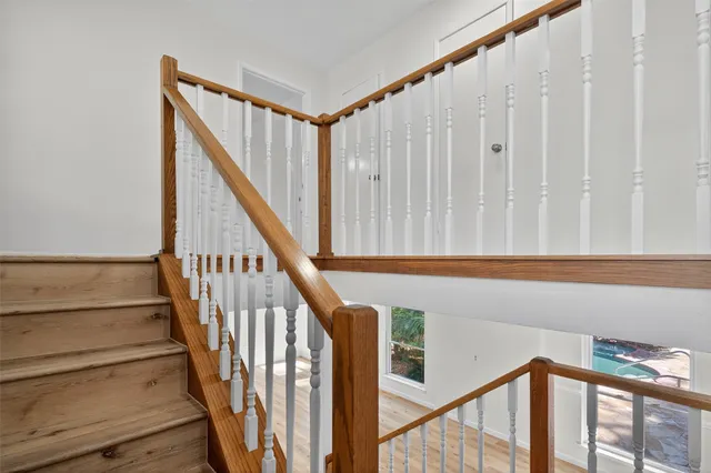 a view of staircase with railing and white walls