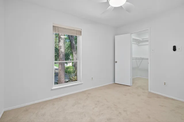 an empty room with a window and a ceiling fan