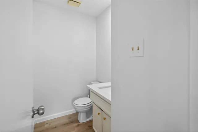 a white toilet sitting next to a white wall