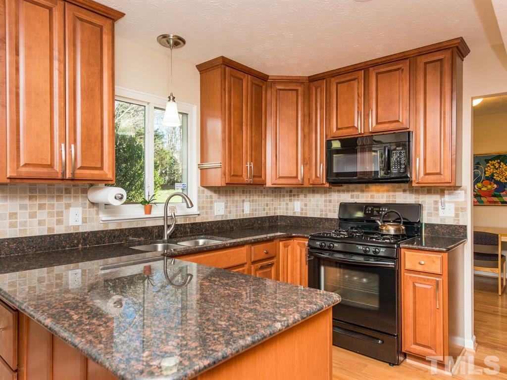 115 Trinity Woods Drive Raleigh, NC 27607 - Photo 2 of 25 a kitchen with a sink a stove and cabinets