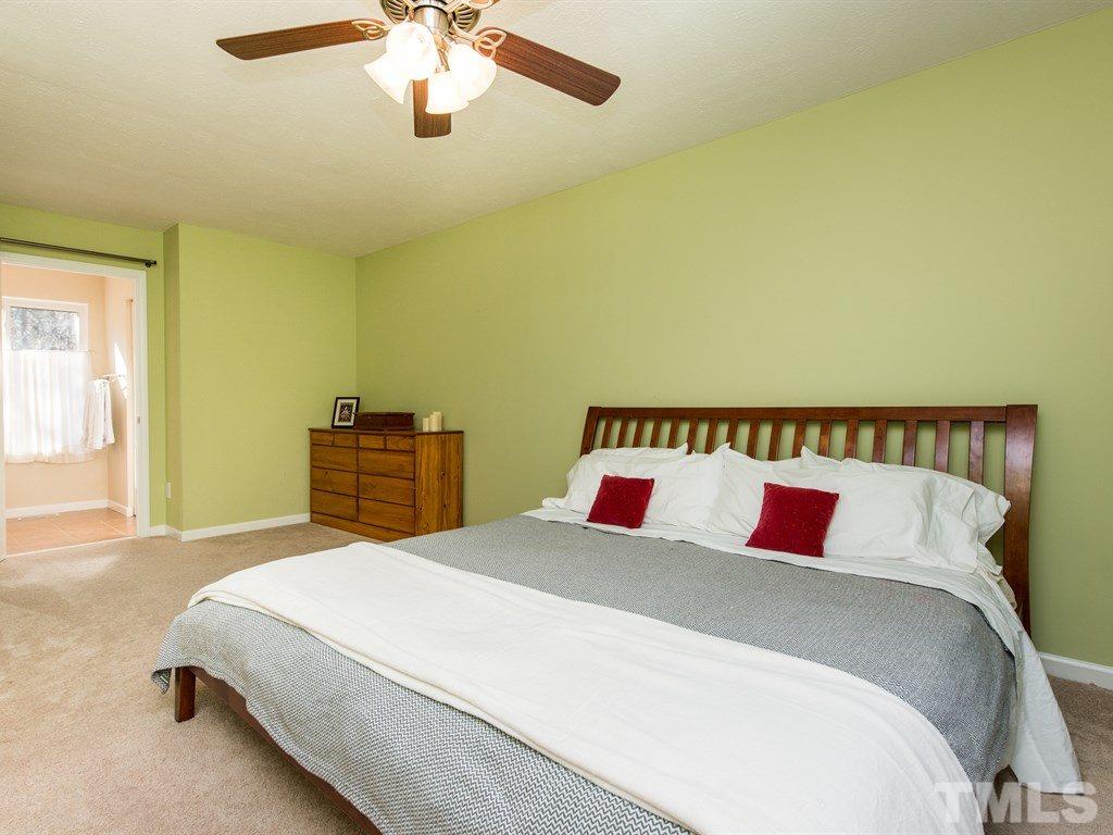 115 Trinity Woods Drive Raleigh, NC 27607 - Photo 15 of 25 a bedroom with a bed and a chandelier