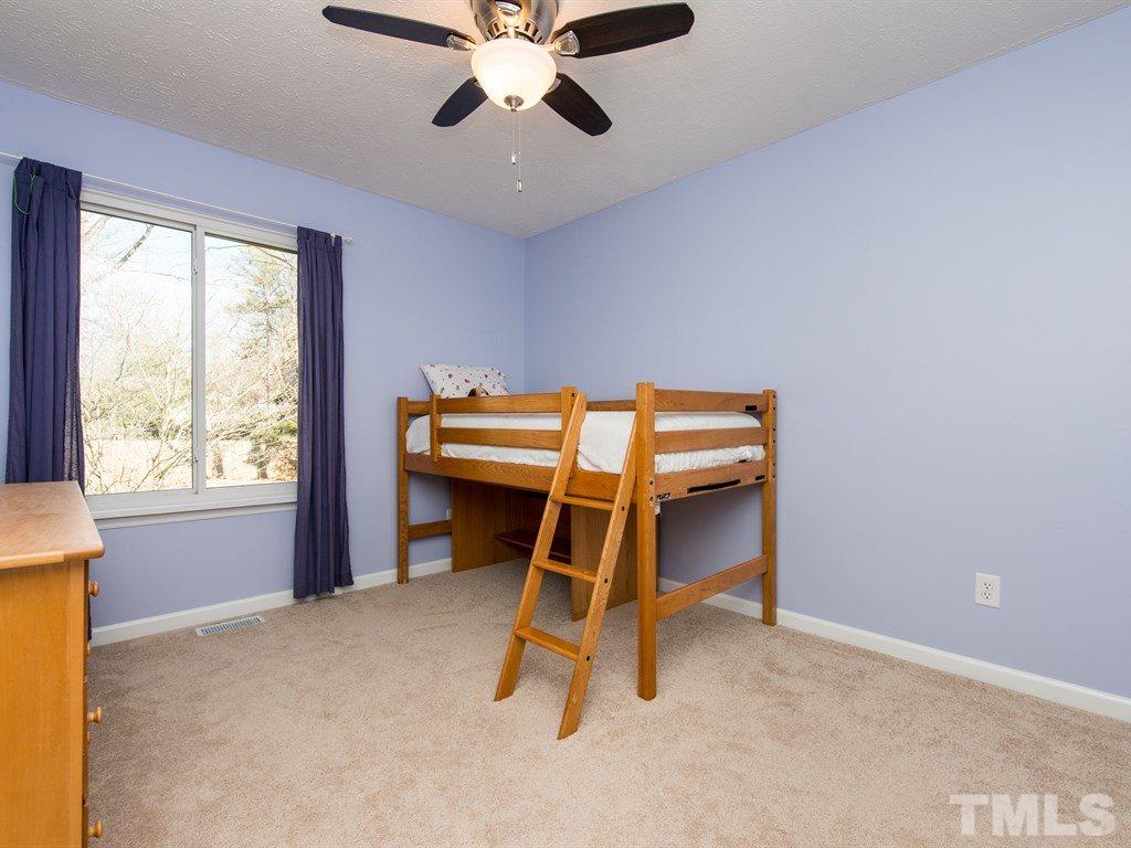 115 Trinity Woods Drive Raleigh, NC 27607 - Photo 17 of 25 a bedroom with a bed and a chandelier
