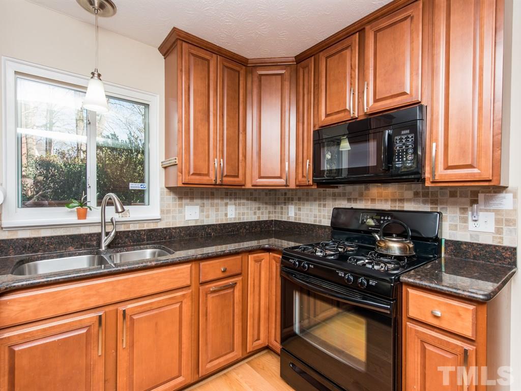 115 Trinity Woods Drive Raleigh, NC 27607 - Photo 3 of 25 a kitchen with granite countertop cabinets stainless steel appliances a sink and a window