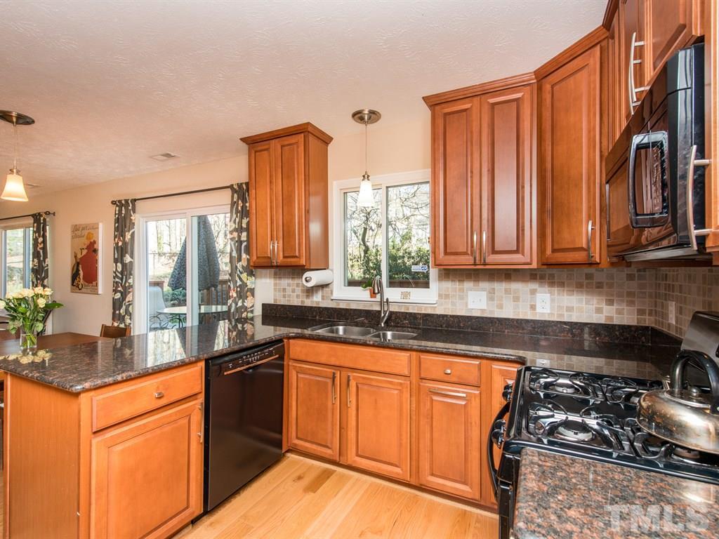 115 Trinity Woods Drive Raleigh, NC 27607 - Photo 6 of 25 a kitchen with stainless steel appliances granite countertop a stove a sink and a microwave