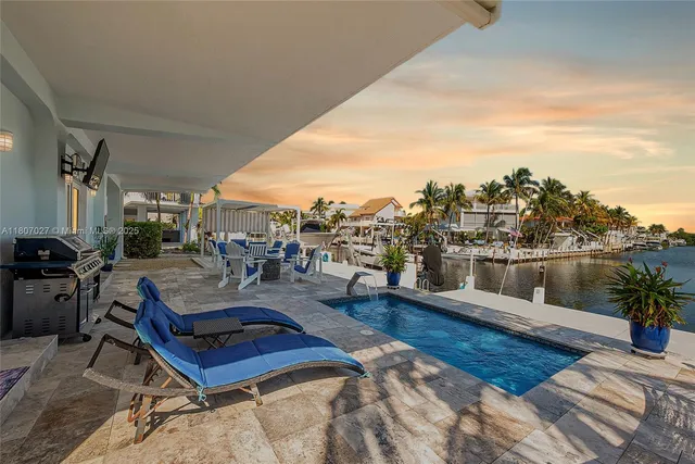 an aerial view of ocean and residential houses with outdoor space