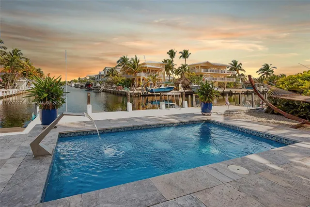 an aerial view of ocean and residential houses with outdoor space