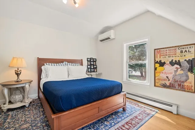 a bedroom with a bed and painting on the wall