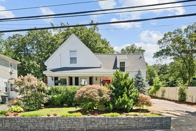 a front view of a house with a yard and potted plants