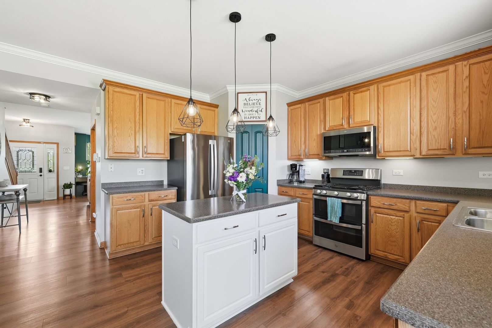 25216 Spring Street Manhattan, IL 60442 - Photo 6 of 28 a kitchen with stainless steel appliances granite countertop a refrigerator a stove top oven a sink dishwasher and white cabinets with wooden floor