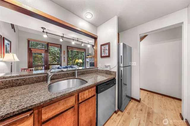 a kitchen with stainless steel appliances granite countertop a sink and a refrigerator