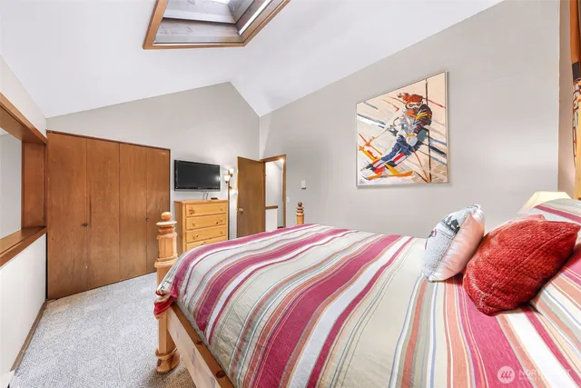 a bedroom with a bed and painting on the wall