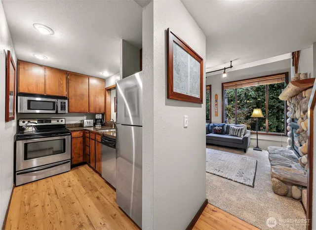 a kitchen with stainless steel appliances kitchen island granite countertop a refrigerator and stove