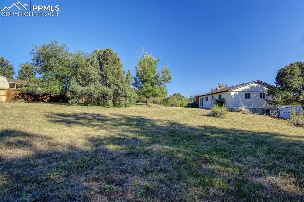 5380 Babcock Court Colorado Springs, CO 80915 - Photo 22 of 28 a backyard of a house with lots of green space and garden