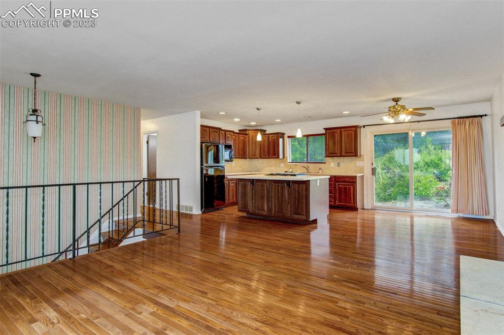 5380 Babcock Court Colorado Springs, CO 80915 - Photo 3 of 28 a open kitchen with stainless steel appliances granite countertop a stove top oven a sink dishwasher and a refrigerator with wooden floor