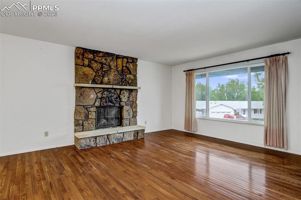 5380 Babcock Court Colorado Springs, CO 80915 - Photo 5 of 28 an empty room with wooden floor and windows