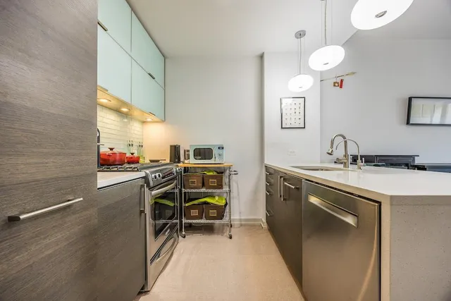 a living room with furniture a wooden floor and kitchen view