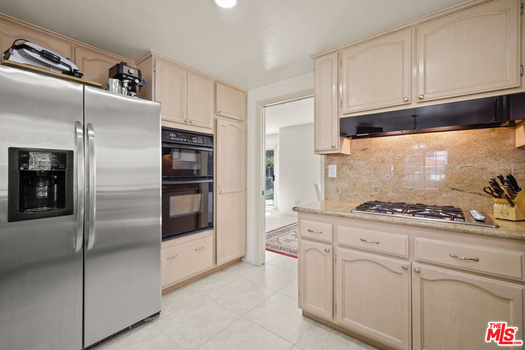 12119 Falcon Crest Way Porter Ranch, CA 91326 - Photo 15 of 51 a kitchen with stainless steel appliances granite countertop a refrigerator and a stove