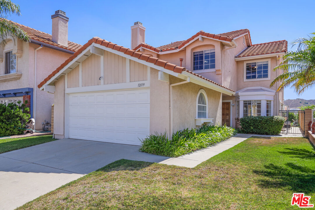 12119 Falcon Crest Way Porter Ranch, CA 91326 - Photo 2 of 51 a front view of a house with a yard and garage