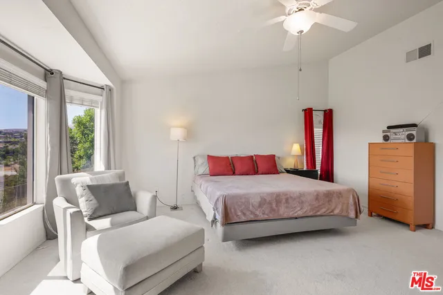 a bedroom with a bed and a ceiling fan