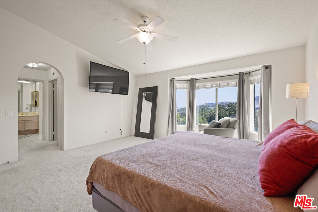12119 Falcon Crest Way Porter Ranch, CA 91326 - Photo 36 of 51 a spacious bedroom with a large bed and a chandelier