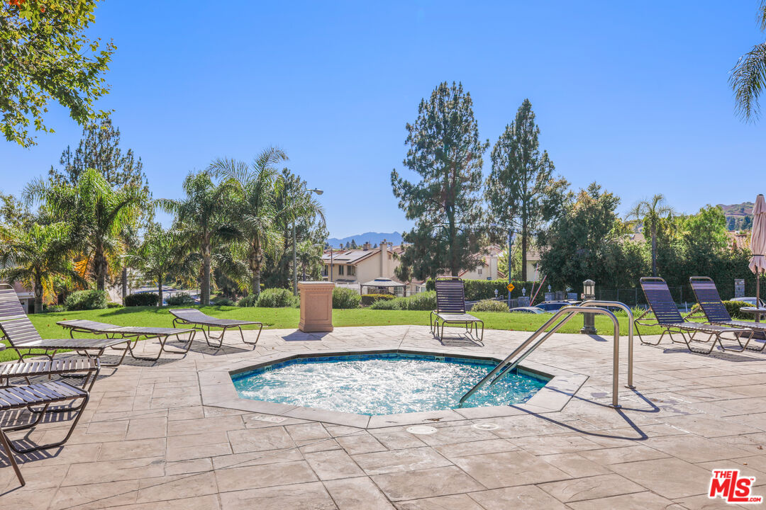 12119 Falcon Crest Way Porter Ranch, CA 91326 - Photo 49 of 51 a view of a swimming pool with a lounge chairs