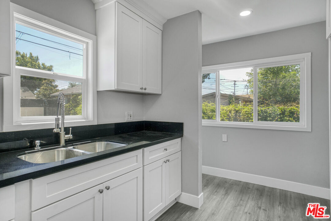 1256 Exposition Boulevard Los Angeles, CA 90007 - Photo 12 of 28 a kitchen with granite countertop a sink and a white wooden cabinets