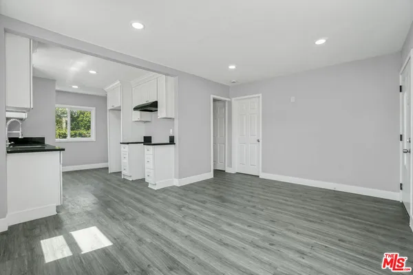 a view of a kitchen with wooden floor and electronic appliances