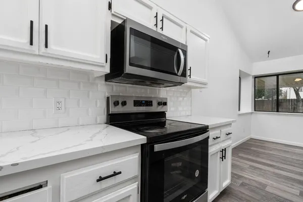 a kitchen with stainless steel appliances a stove microwave and refrigerator