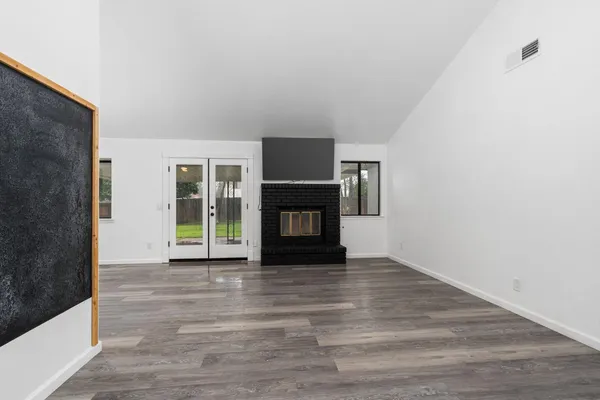 a view of an empty room with a fireplace and a window