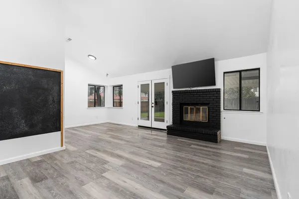 a view of empty room with wooden floor