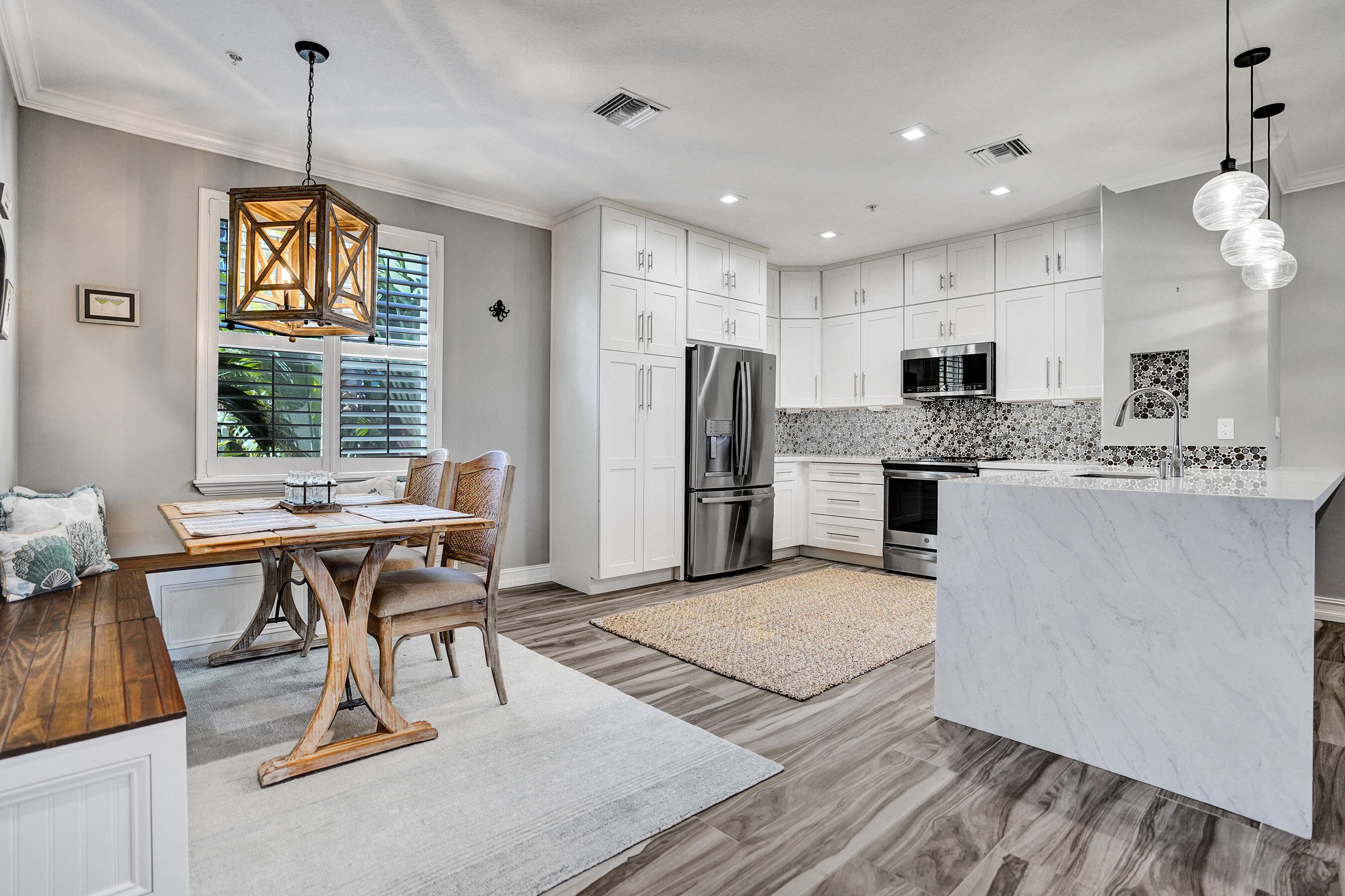 314 Northwest 1st Street Delray Beach, FL 33444 - Photo 8 of 26 a open kitchen with stainless steel appliances granite countertop a stove top oven a refrigerator a sink dishwasher a dining table and chairs with wooden floor