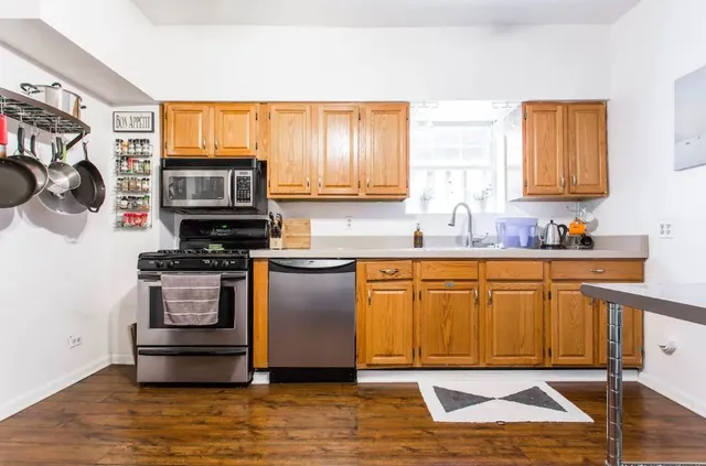 a kitchen with stainless steel appliances granite countertop a stove a sink and a microwave