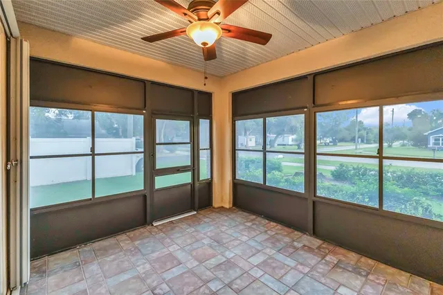 a view of an empty room window and a ceiling fan