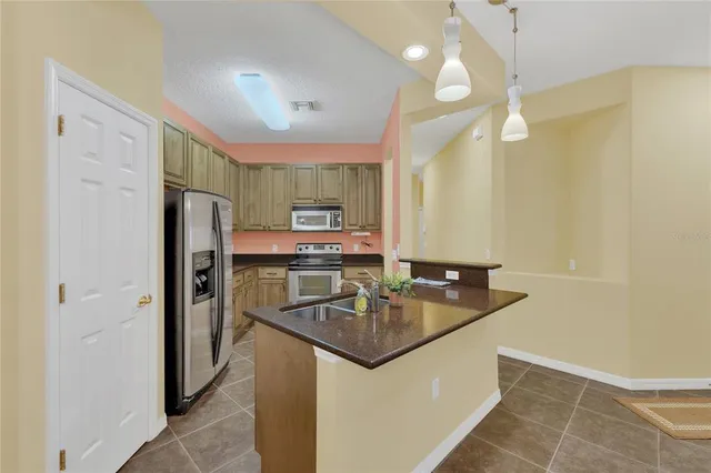 a kitchen with stainless steel appliances granite countertop a sink refrigerator and cabinets