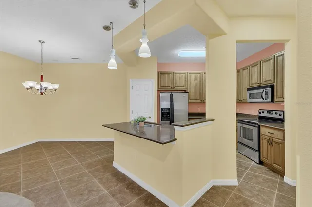 a kitchen with stainless steel appliances granite countertop a sink a stove and a refrigerator