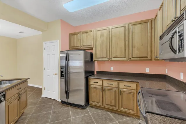 a kitchen with stainless steel appliances granite countertop a refrigerator and a stove top oven