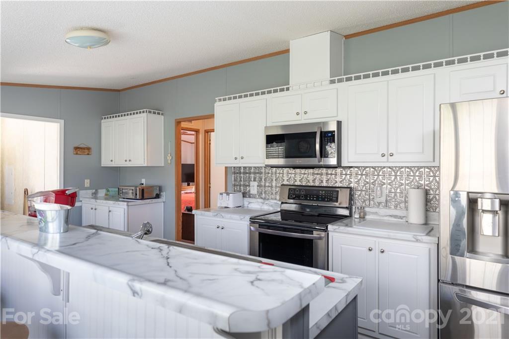 1465 Humphries Road Clover, SC 29710 - Photo 8 of 47 a kitchen with granite countertop a sink stainless steel appliances and white cabinets