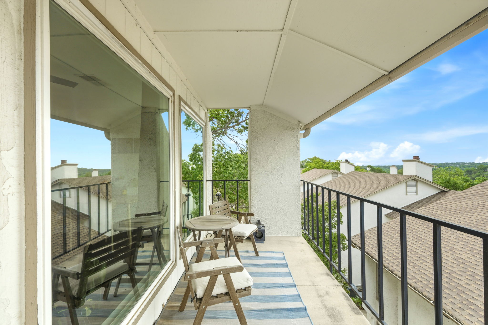 6910 Hart Lane, Unit 912 Austin, TX 78731 - Photo 4 of 36 Covered balcony featuring concrete flooring and a black metal railing