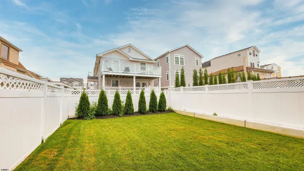 a view of a white house with a yard