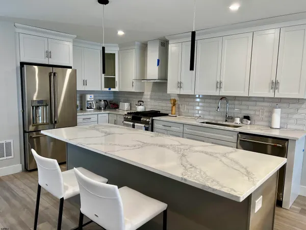 a kitchen with stainless steel appliances granite countertop a sink refrigerator and cabinets