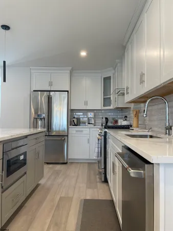 a kitchen with stainless steel appliances granite countertop a sink stove and refrigerator