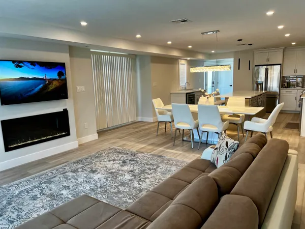 a living room with furniture a flat screen tv and a fireplace