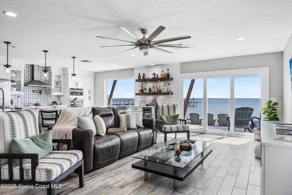 a living room with furniture and a view of kitchen